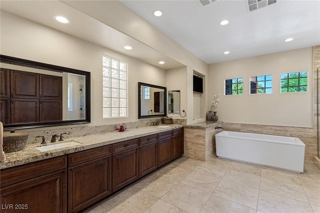 bathroom with vanity, a washtub, and tile patterned floors