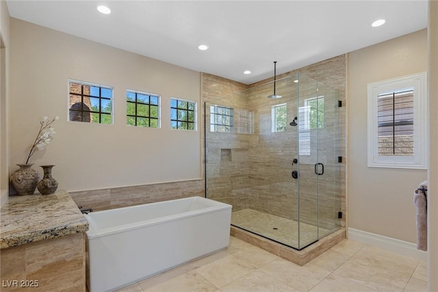 bathroom featuring plenty of natural light and separate shower and tub