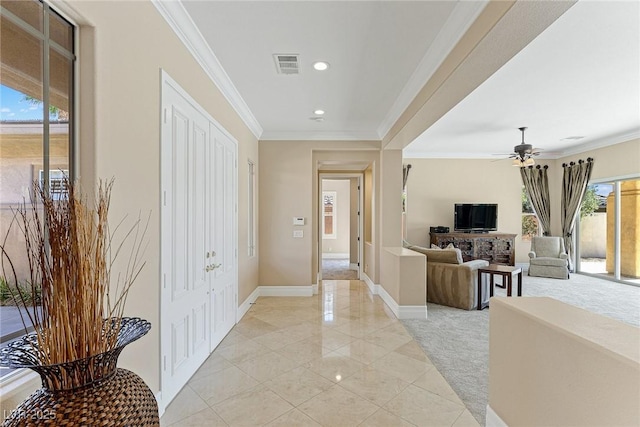 hallway with crown molding and light tile patterned floors