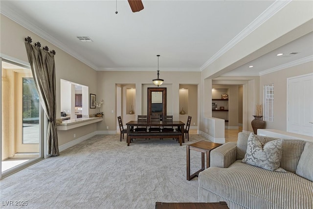 carpeted living room with ornamental molding and ceiling fan