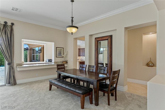 carpeted dining room featuring crown molding