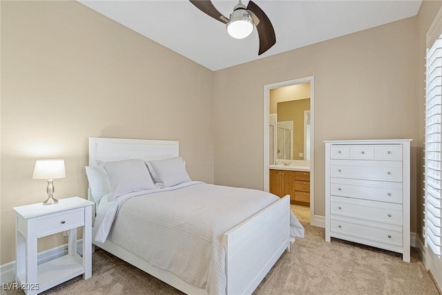 bedroom featuring connected bathroom, light colored carpet, and ceiling fan