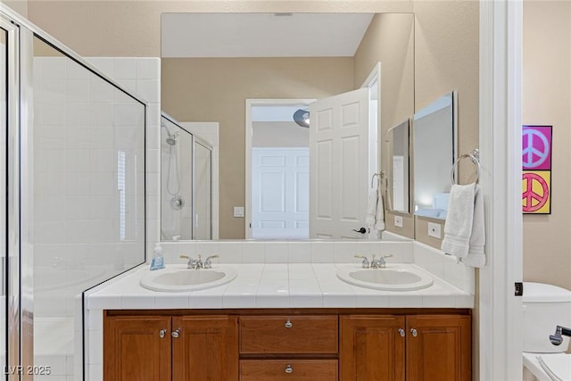 bathroom with a shower with door, vanity, and toilet