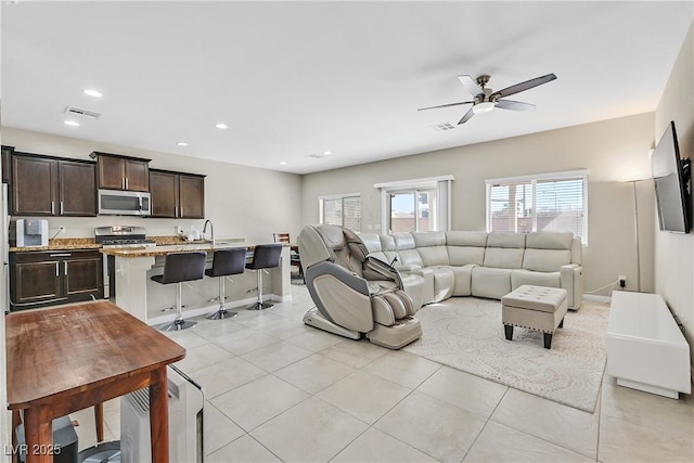 tiled living room featuring sink and ceiling fan