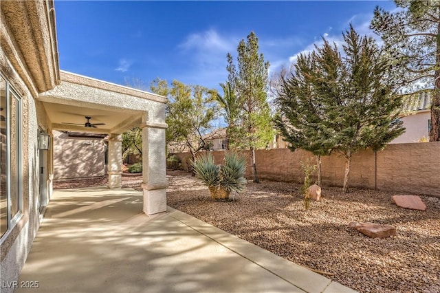 view of yard featuring a patio area, ceiling fan, and a fenced backyard