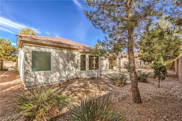 rear view of house with a patio area and stucco siding