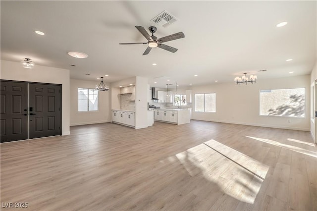 unfurnished living room featuring light wood-style floors, recessed lighting, visible vents, and a healthy amount of sunlight