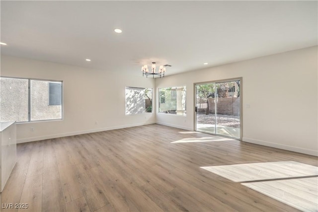 unfurnished room featuring baseboards, recessed lighting, a chandelier, and light wood-style floors