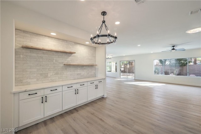 kitchen featuring open shelves, backsplash, visible vents, and light wood-style floors