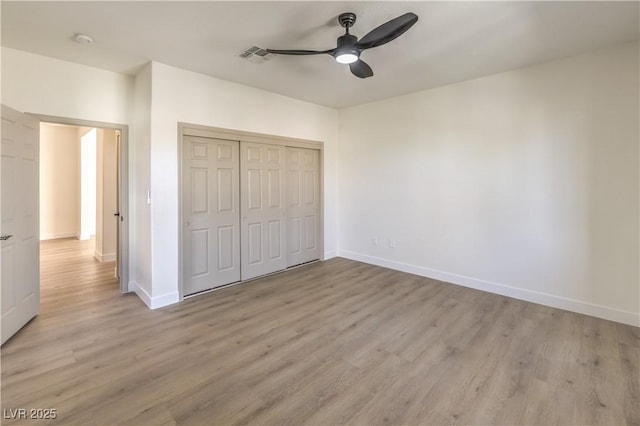 unfurnished bedroom with a ceiling fan, baseboards, visible vents, light wood-style floors, and a closet