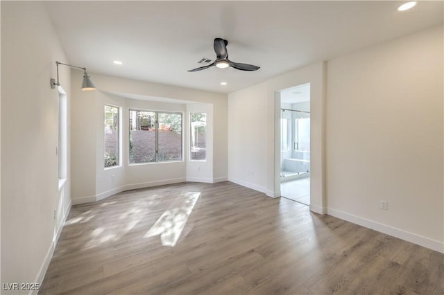 empty room with recessed lighting, visible vents, ceiling fan, wood finished floors, and baseboards