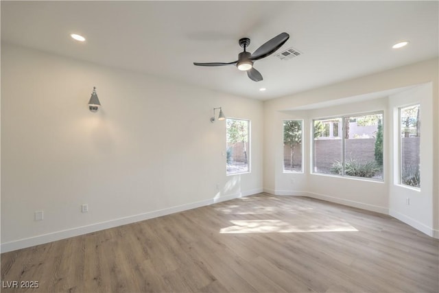 spare room featuring light wood-style flooring, visible vents, baseboards, and recessed lighting