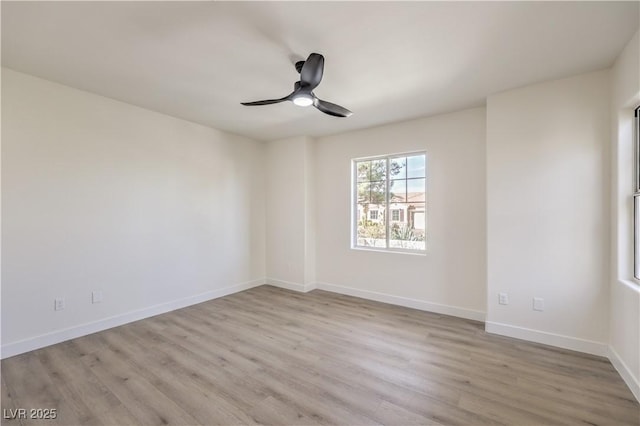 spare room featuring a ceiling fan, baseboards, and wood finished floors