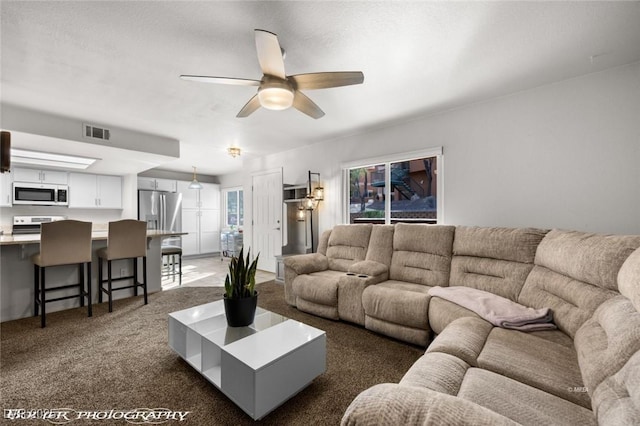 carpeted living room featuring ceiling fan