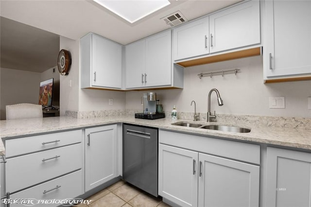 kitchen with sink, white cabinetry, light tile patterned floors, dishwasher, and light stone countertops