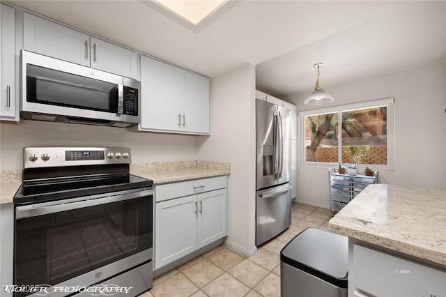 kitchen featuring pendant lighting, stainless steel appliances, light stone countertops, and white cabinets