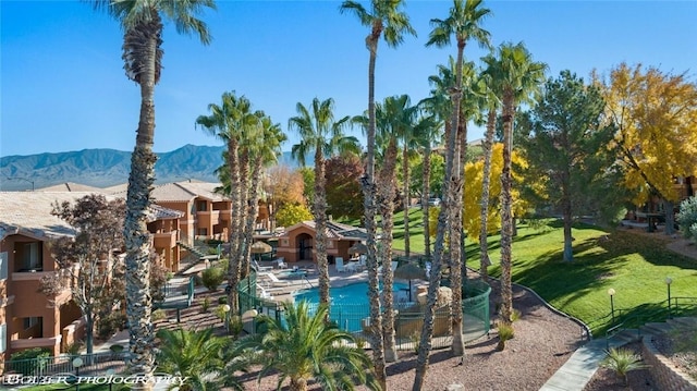 view of home's community with a mountain view and a lawn