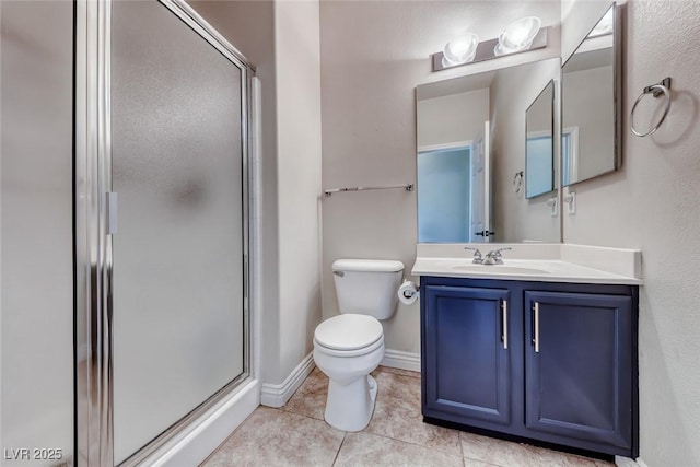 bathroom with vanity, toilet, tile patterned flooring, and a shower with door