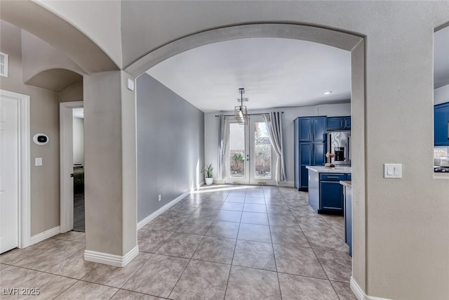 unfurnished dining area with light tile patterned floors and french doors