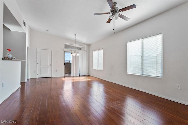 unfurnished living room with lofted ceiling, dark wood-type flooring, and ceiling fan with notable chandelier