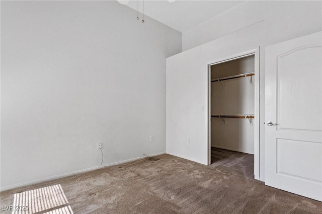 unfurnished bedroom with a walk in closet, a closet, and carpet flooring