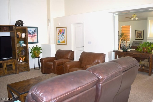 carpeted living area with a ceiling fan