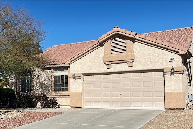 view of front of home featuring stucco siding, driveway, a tile roof, and a garage
