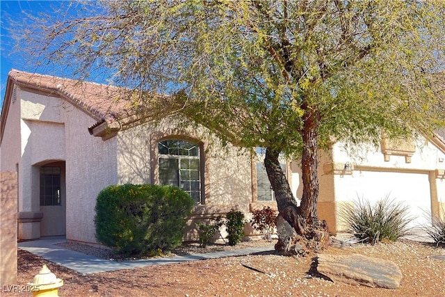 view of front facade with a tile roof and stucco siding