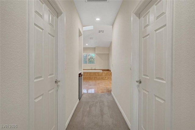 hallway with carpet floors, recessed lighting, visible vents, and baseboards