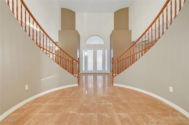 entryway featuring stairs, french doors, a high ceiling, and baseboards