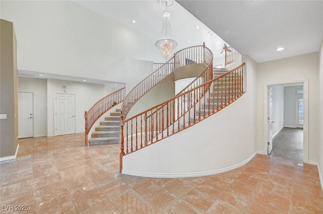 stairway with baseboards, a high ceiling, a chandelier, and recessed lighting