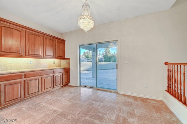 interior space featuring an inviting chandelier and baseboards