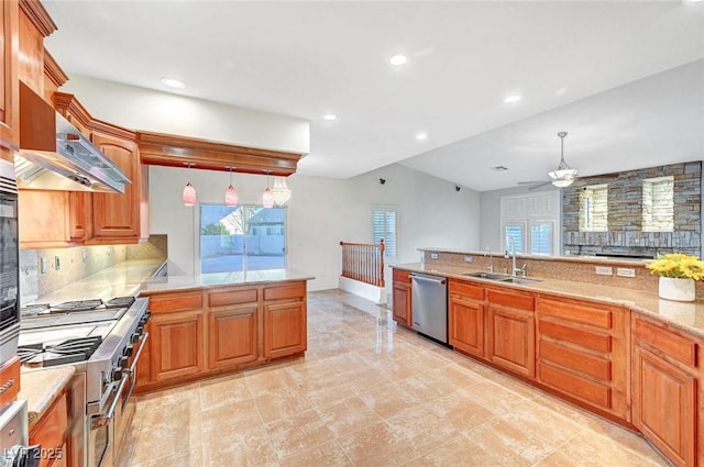 kitchen with appliances with stainless steel finishes, pendant lighting, brown cabinetry, and a sink