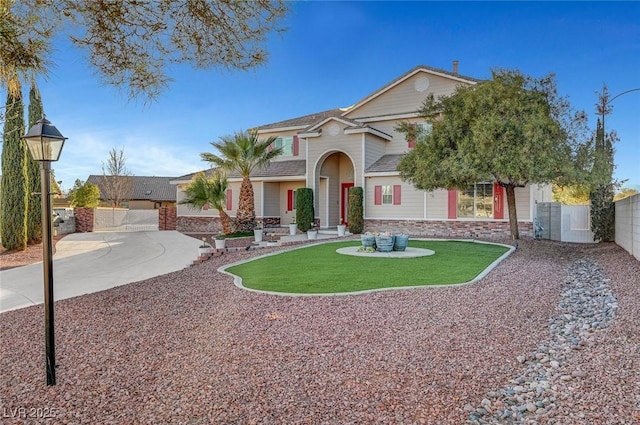 view of front of house with fence, a front lawn, concrete driveway, and brick siding