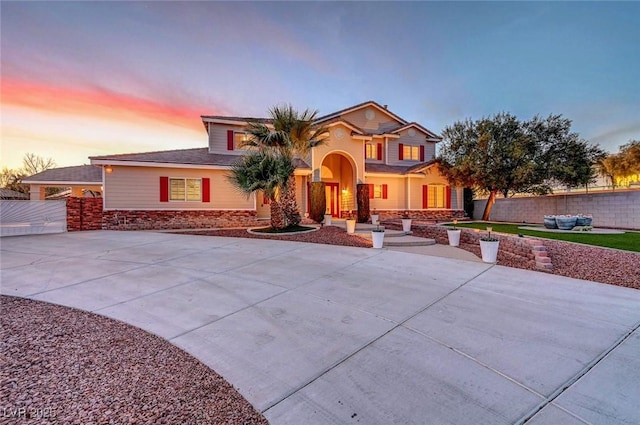 view of front of house with fence and concrete driveway