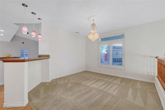 empty room with light carpet, a notable chandelier, and baseboards