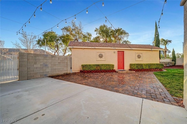 exterior space with a patio area, fence, and stucco siding