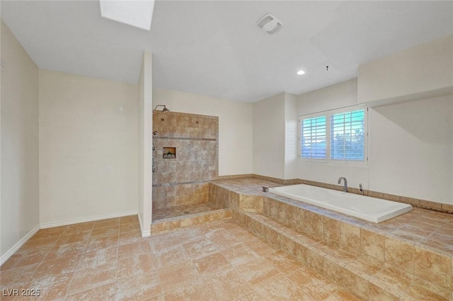 bathroom with a garden tub, walk in shower, and baseboards