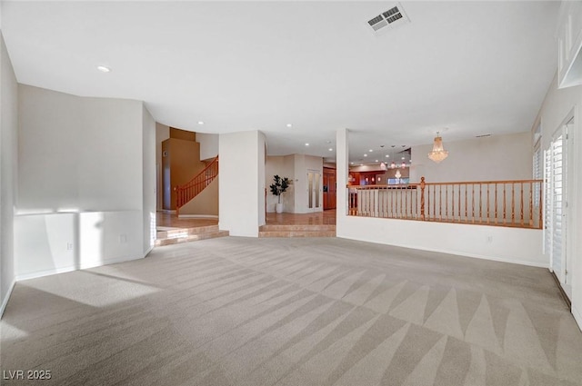 unfurnished living room featuring recessed lighting, light colored carpet, visible vents, baseboards, and stairway