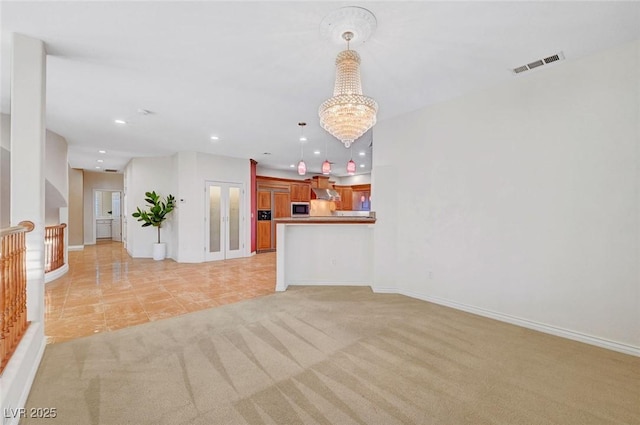 unfurnished living room featuring a notable chandelier, light carpet, recessed lighting, visible vents, and baseboards