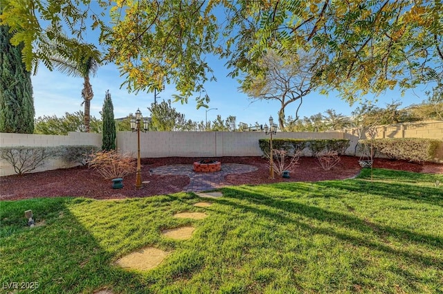 view of yard with a fenced backyard and a fire pit