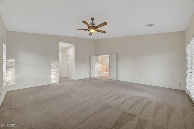 unfurnished bedroom with baseboards, visible vents, lofted ceiling, ensuite bath, and carpet flooring