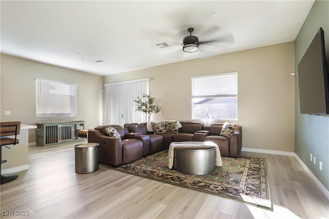 living room with ceiling fan and light hardwood / wood-style flooring