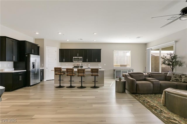 living room featuring ceiling fan and light hardwood / wood-style flooring