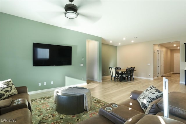 living room featuring ceiling fan and light wood-type flooring