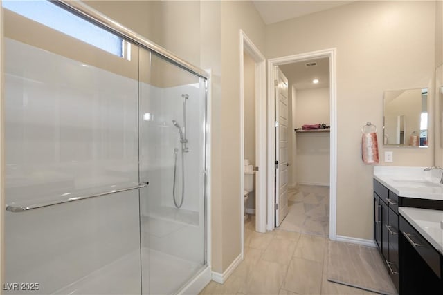 bathroom featuring walk in shower, vanity, and toilet