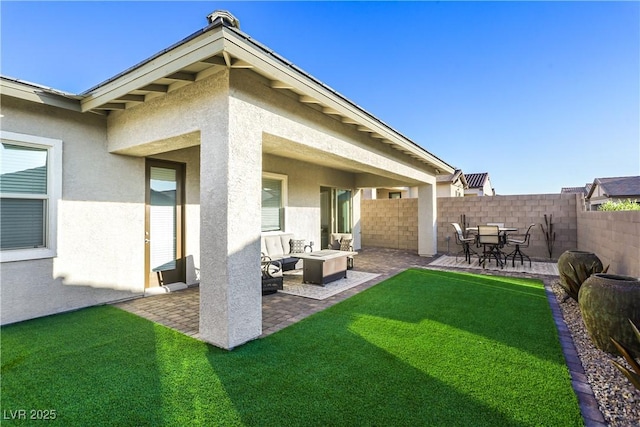 back of property with a lawn and a patio