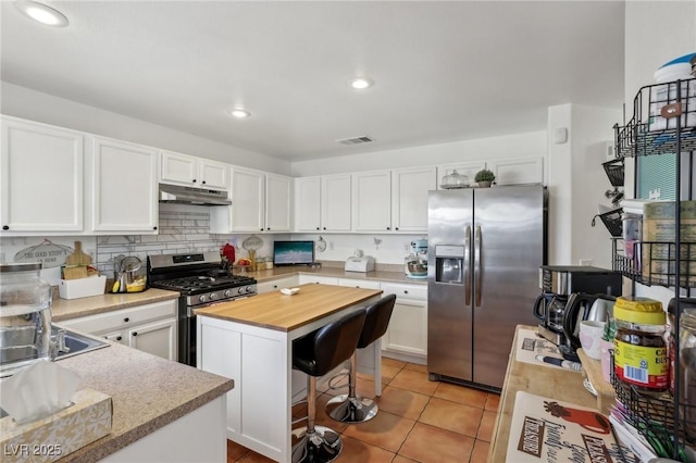 6527 Netherseal Ave, Las Vegas, NV 89139 - kitchen featuring appliances with stainless steel finishes, a kitchen breakfast bar, a center island, white cabinets, and light tile patterned flooring