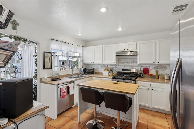 6527 Netherseal Ave, Las Vegas, NV 89139 - kitchen featuring white cabinetry, sink, decorative backsplash, and stainless steel appliances