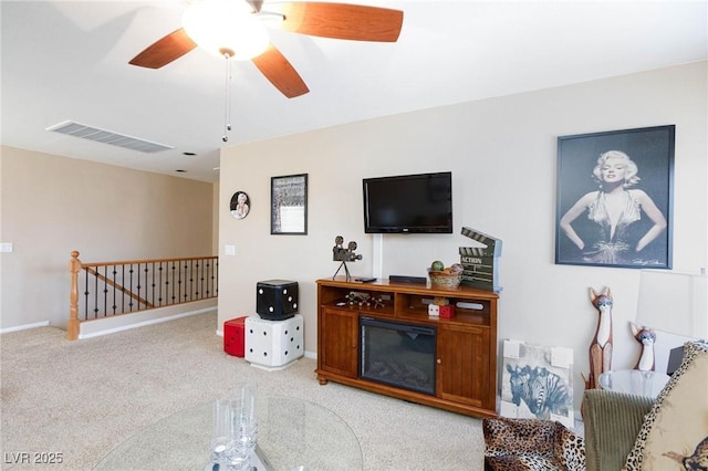 carpeted living room with ceiling fan